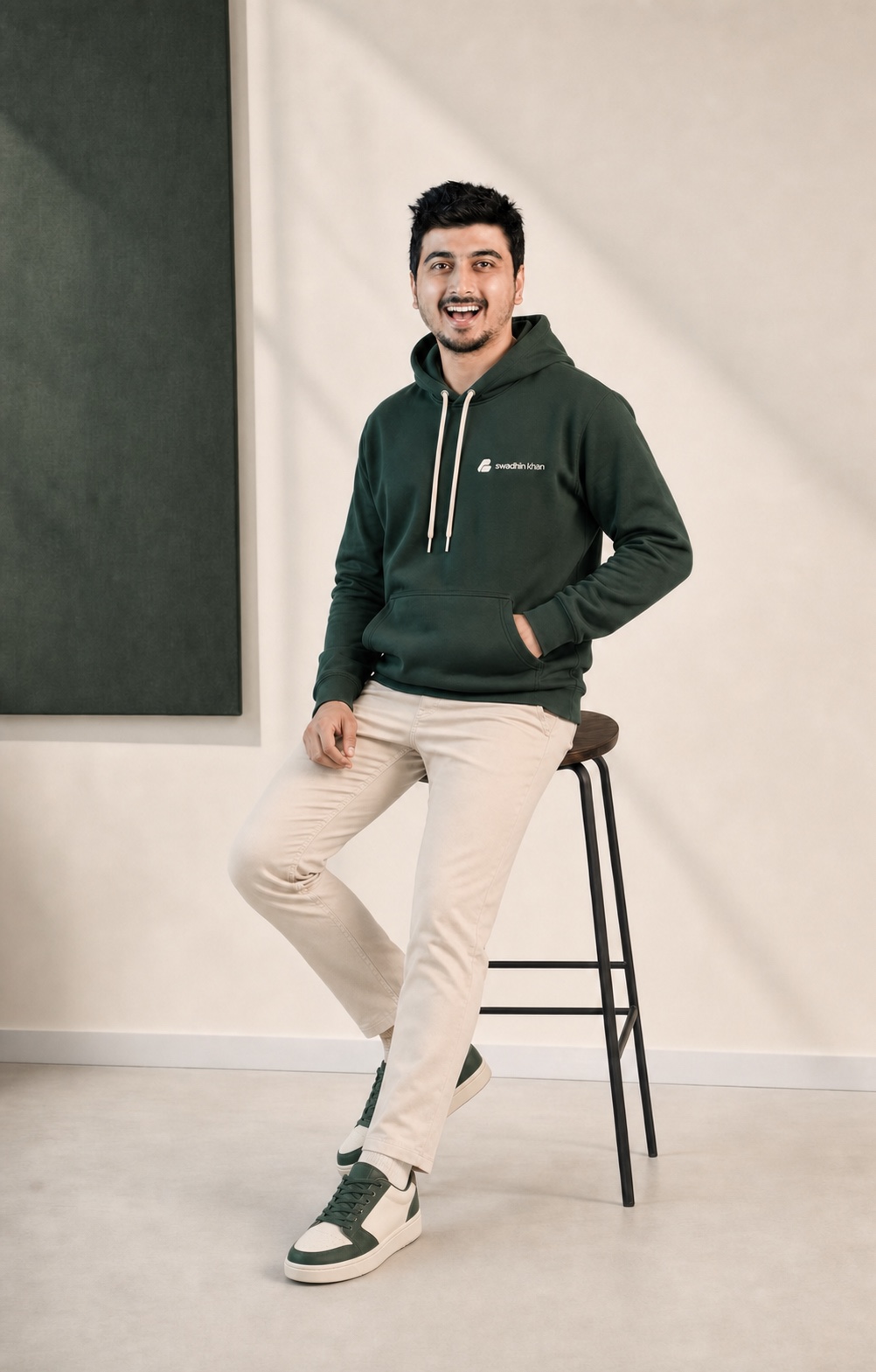 Official Swadhin Khan full logo-সহ forest green hoodie পরা Swadhin Khan-এর energetic full-body portrait