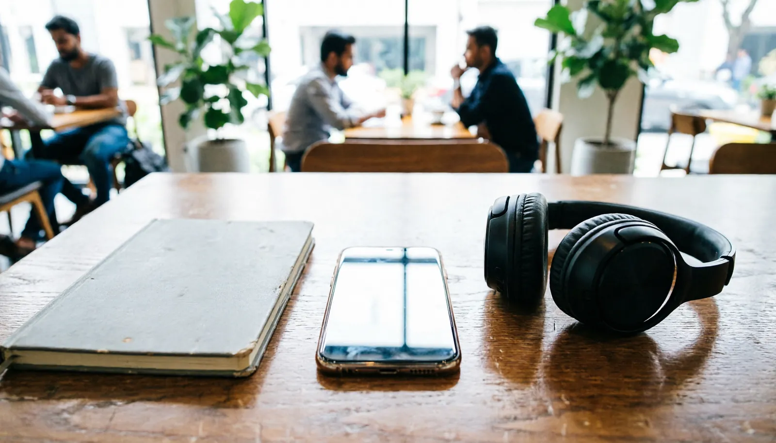 Smartphone and notebook on a cafe table showing alternative registration methods.